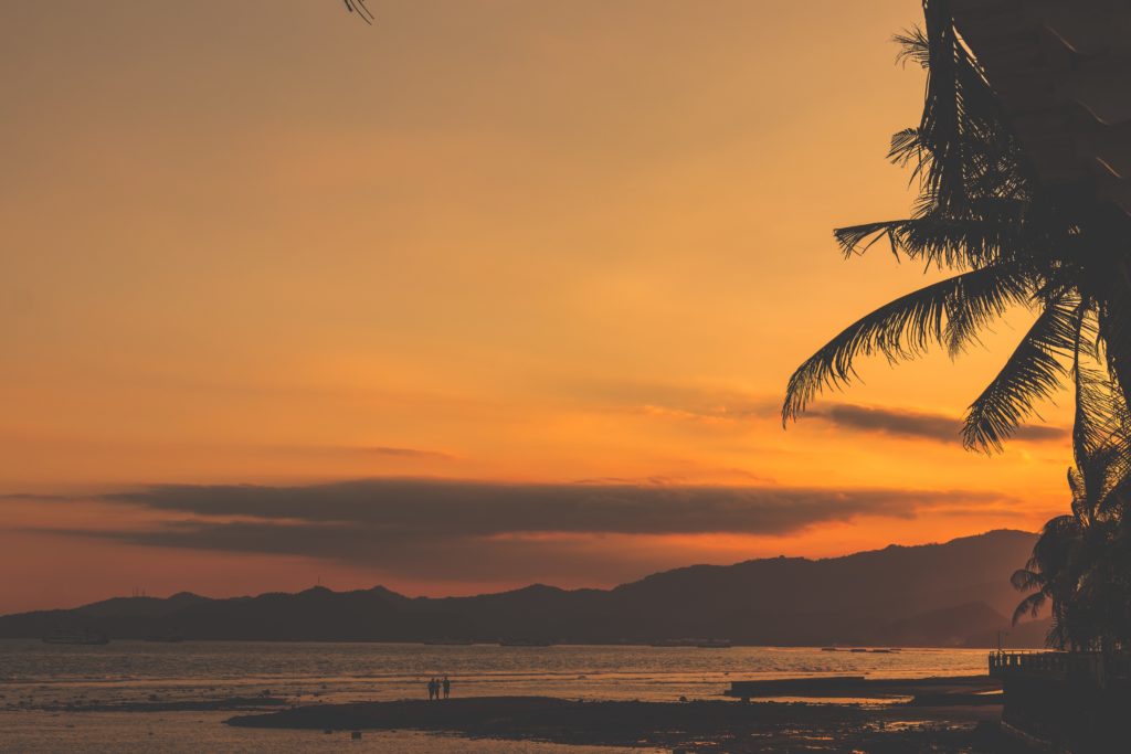 Un superbe coucher de soleil en Thaïlande avec des palmiers.