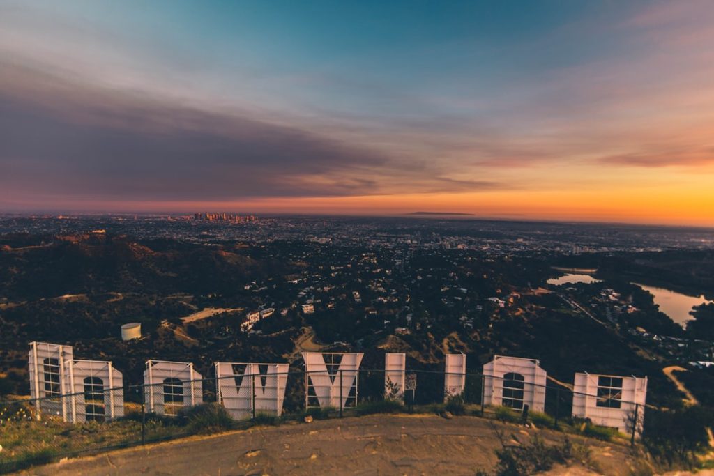Foto del famoso letrero de Hollywood tomado desde atrás y con la puesta de sol de fondo.