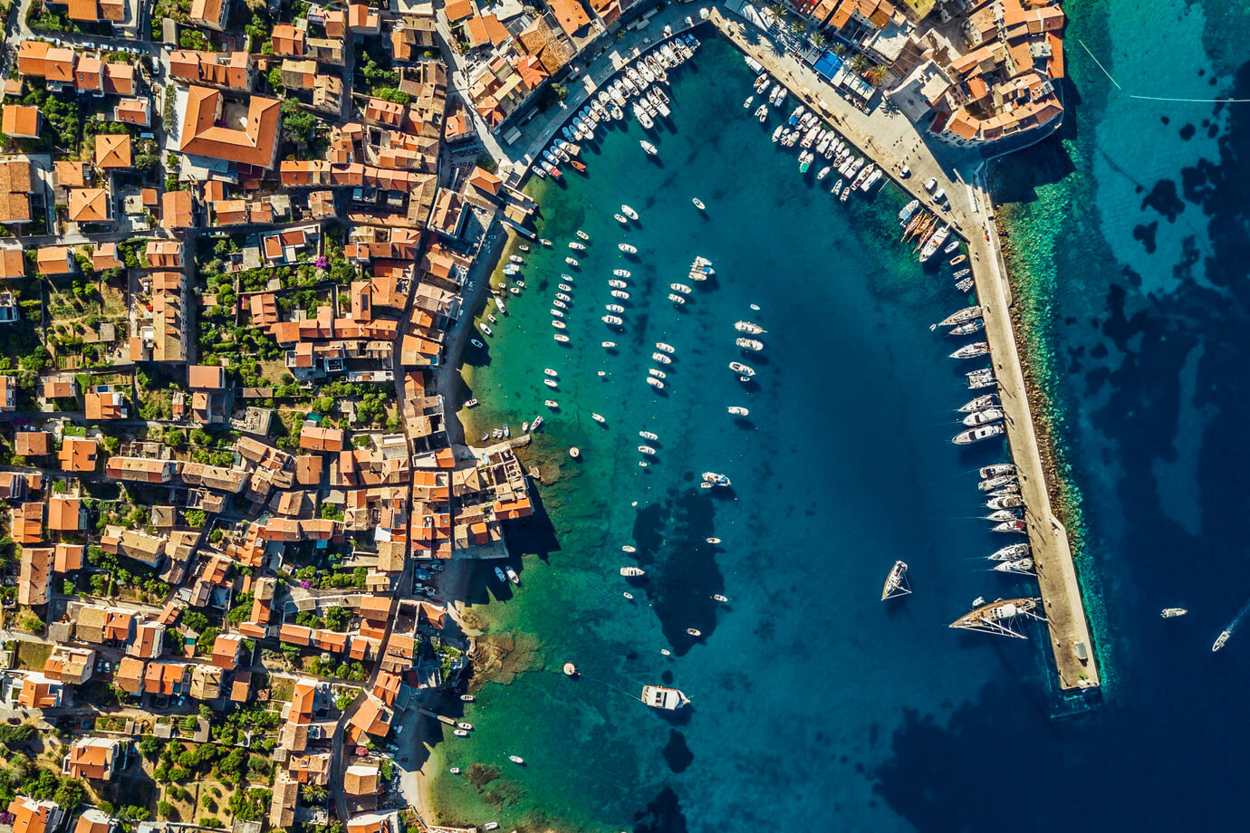 Drone View on a Beach Bay. Aerial View of a Coastal City with Red Roofs near Yacht Harbor. Luxury Summer Vacation in Dubrovnik. Croatia.