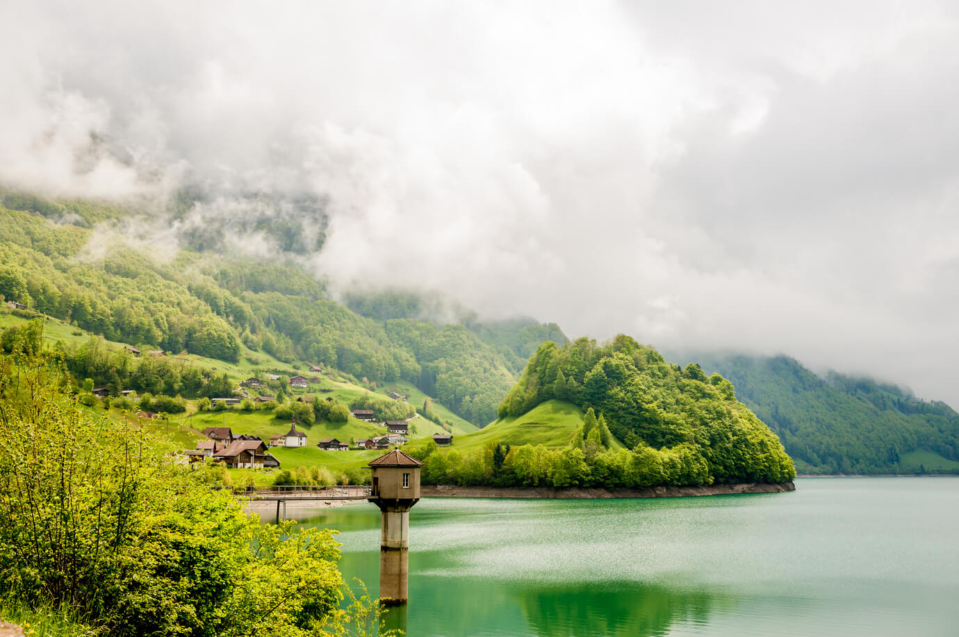 Beautiful emerald mountain lake Lungern in Switzerland under low clouds