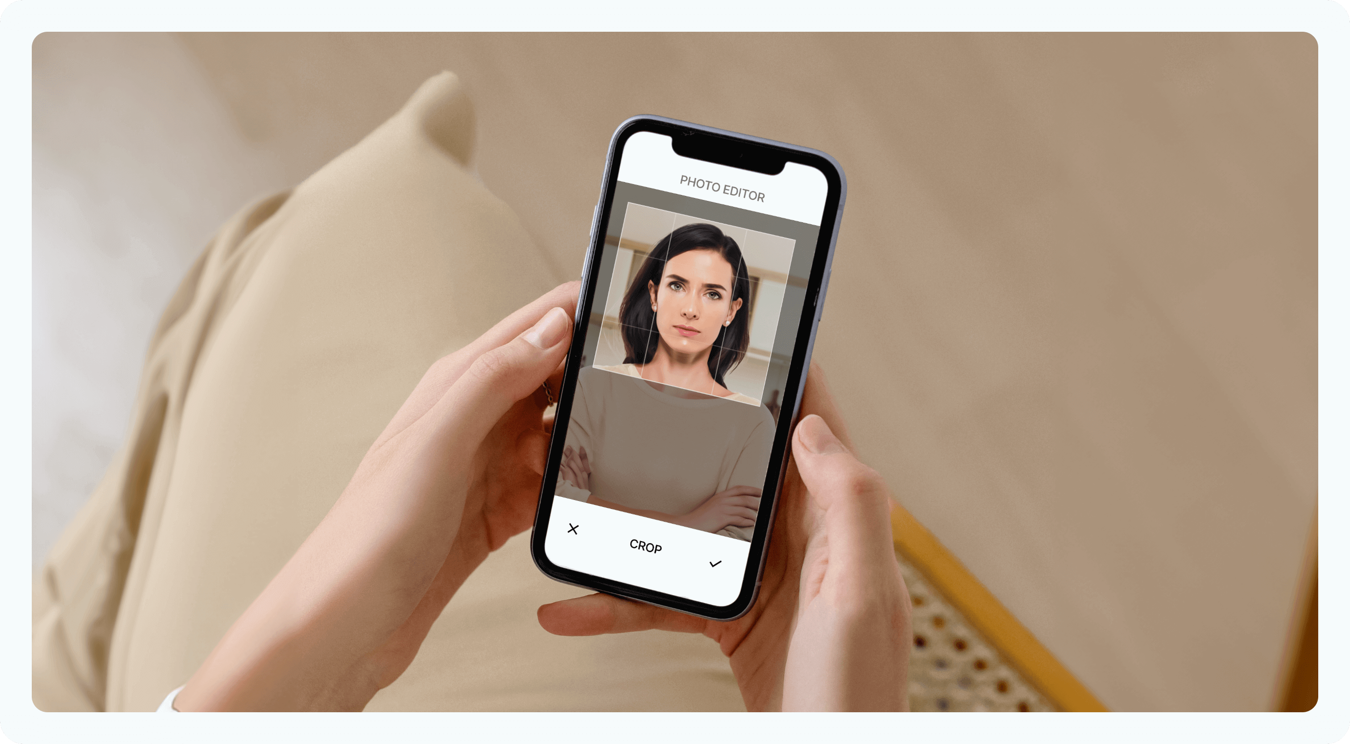 A woman editing a passport photo on her smartphone. She’s holding an ID in her hand, and you can see that the photo there is the one she took on her phone.